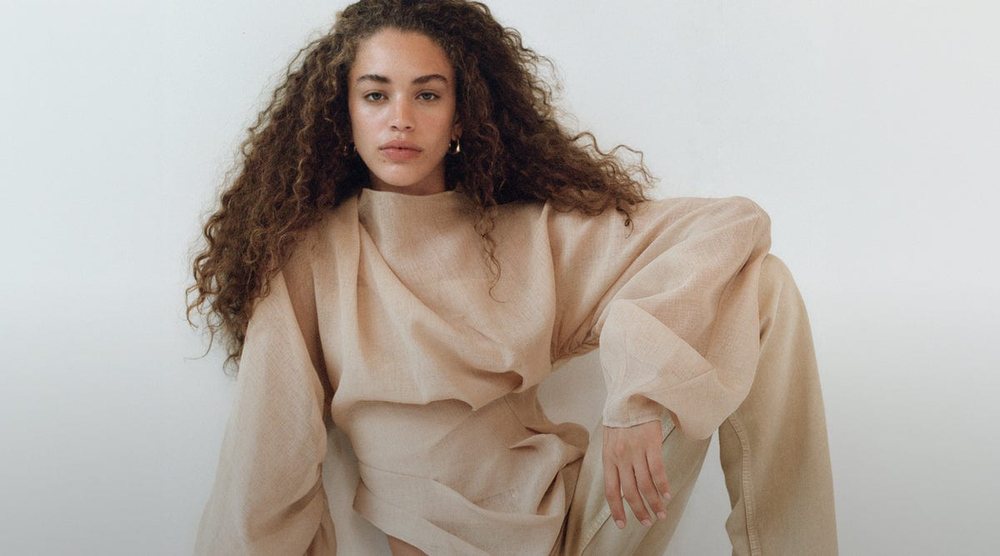 Aje campaign: a model in a draped neutral top